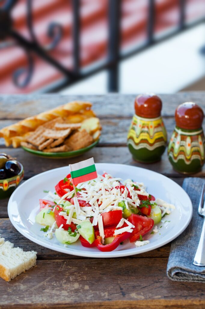 Vegetable Bulgarian Shopska Salad with Bulgaria flag. Wooden background.